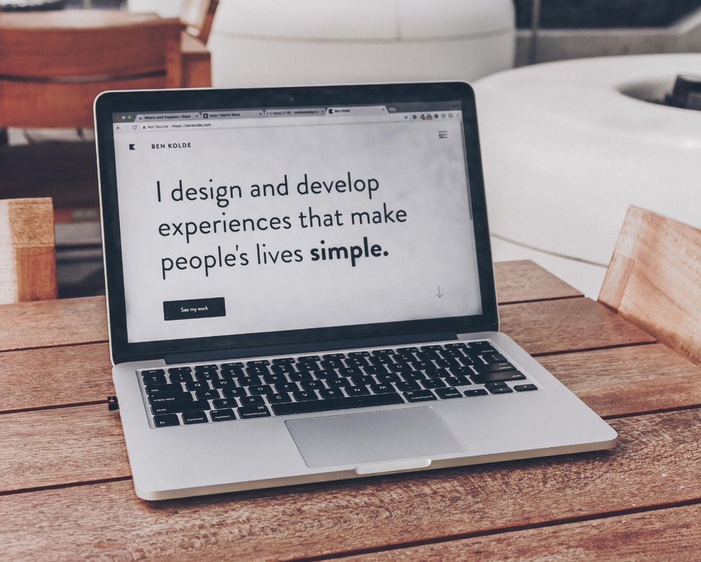 laptop screen with text that reads I design and develop experiences that make people's lives simple